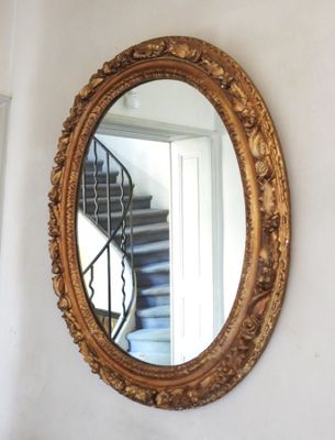 a mirror hanging on the wall next to a stair case