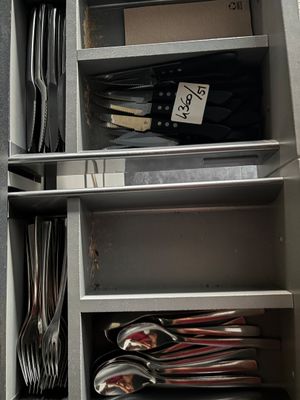 beaucoup de cuillères et de fourchettes dans une armoire en métal
