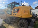 a picture of a cat excavator parked in a yard