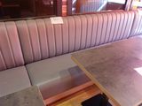 une cabine avec une table et un banc devant une fenêtre