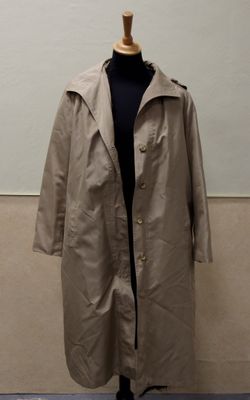 an image of a coat on a mannequin stand in front of a wall