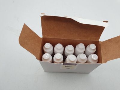une boîte en carton remplie de bouteilles contenant un liquide, posée sur une surface blanche