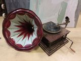 a red and white gramphone sitting on top of a wooden table