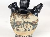 a black and white vase with a painting on it
