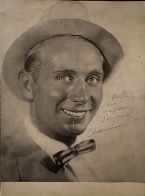 a black and white photo of a man with a hat and bow tie