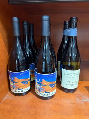Plusieurs bouteilles de vin sont alignées sur une étagère dans un placard
