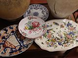 de nombreuses assiettes et bols posés sur une table, avec un vase en arrière-plan