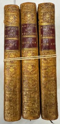 trois vieux livres posés l'un sur l'autre sur une table