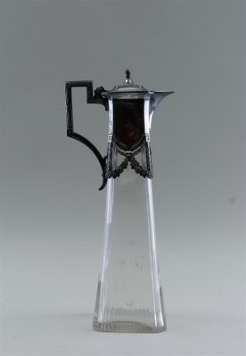un pichet en verre muni d'une anse, sur fond blanc