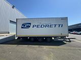 un grand camion blanc garé devant un immeuble