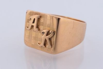 an image of a gold signet ring with the letter r on it