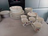 a lot of plates and cups sitting on the counter