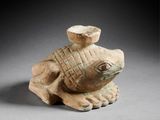 une figurine ancienne représentant une tortue coiffée d'un chapeau