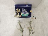 Deux paires de boucles d'oreilles et un sac à main sont posés sur une table.