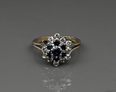 a yellow gold ring with a blue sapphire and white diamonds