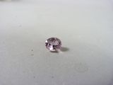 un gros plan d'un diamant rose sur une surface blanche