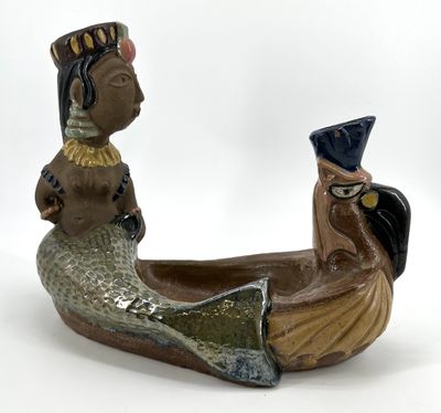 une figurine en céramique représentant une femme et un homme dans un bateau