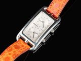an orange watch with a silver case on a black background