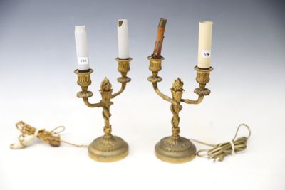 pair of antique brass candlesticks with white candles on them