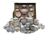 a lot of pink and white dishes and cups in a box