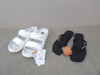 a pair of white sandals and a pair of black sandals next to each other