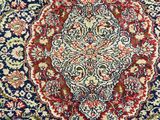 a blue and red rug with a medallion design on it