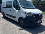 La camionnette blanche est garée sur le parking, à côté d'une clôture.
