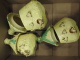 three green vases in a cardboard box with faces painted on them