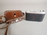 two old cameras sitting next to each other on a table