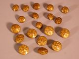 Des pépites d'or sont disposées en cercle sur une surface blanche
