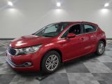 une voiture rouge est garée sur le sol en damier d'un garage