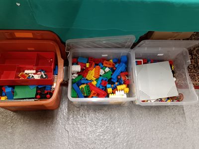 two bins with legos and a laptop on the floor