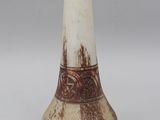 a white and brown vase sitting on a table