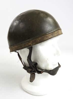 un vieux casque posé sur la tête d'un mannequin, sur une surface blanche