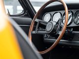 dashboard of a classic car with a wooden steering wheel and gauges