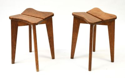 une paire de tabourets en bois aux pieds courbés, sur fond blanc