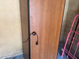 a wooden cabinet with a door and a pink rack in front of it