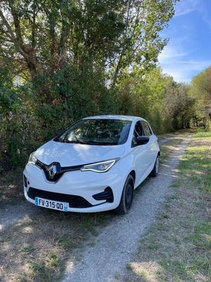 a white car parked on the side of a dirt road