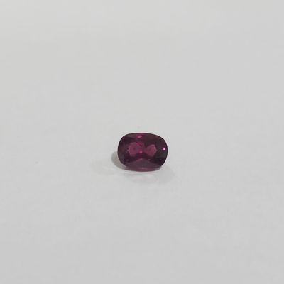 a purple sapphire stone on a white surface