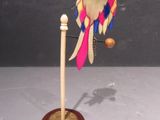 a bird that is sitting on a stand with a ball