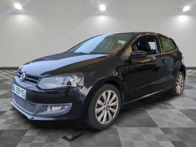 La Volkswagen Polo noire est garée dans une pièce dont le sol est en damier.