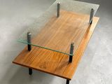 a glass coffee table with a wooden base and metal legs