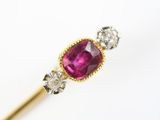 un gros plan d'une bague en pierre rose et diamants posée sur un bâtonnet