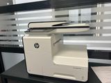 a printer sitting on a desk in front of a window