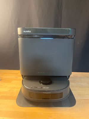 an open laptop computer sitting on top of a stand on top of a wooden table
