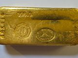 a close up of a gold bar on a white surface