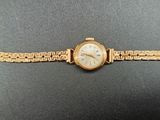 an image of a gold wrist watch with a chain around it