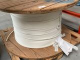 a spool of white wire on a pallet in a warehouse