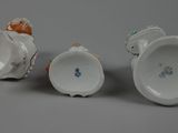 three porcelain cups and saucers sitting on top of a table