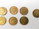 six types différents de pièces d'or sont représentés sur un fond blanc